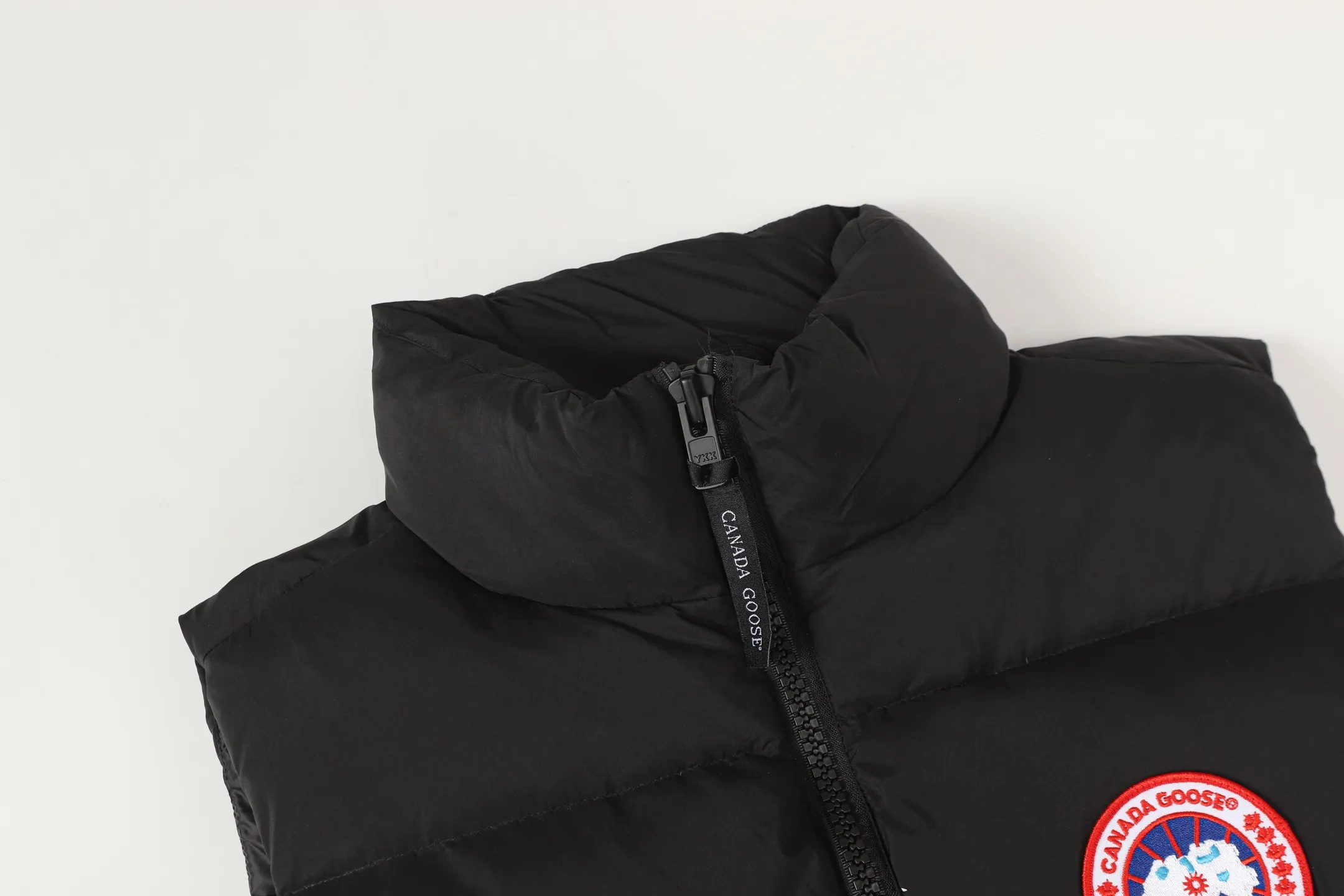 P560 Canada gooes Lawrence down vest (high version) The Lawrence down vest features a durable shell and quilted body, making it a must-have item for all seasons. The fabric has a durable soft touch. Longer hem at back for added protection. Reflective double-stripe grip tape at back. The Lawrence features an engineered down-filled collar to block strong winds, a two-way front zip and a longer rear hem.  Color: black with red label, black with black label, desert color, ocean blue Size: XS-2XL